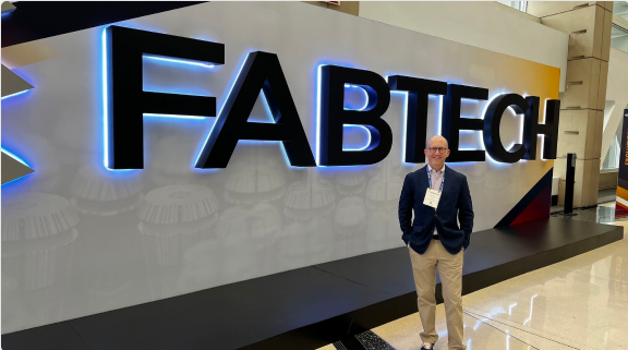 Mike Mayer in front of Fabtech logo.